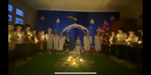 Dzieci stoją z lampionami.